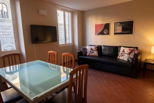 a living room with a glass table and a couch at Residenza Roma in Pistoia