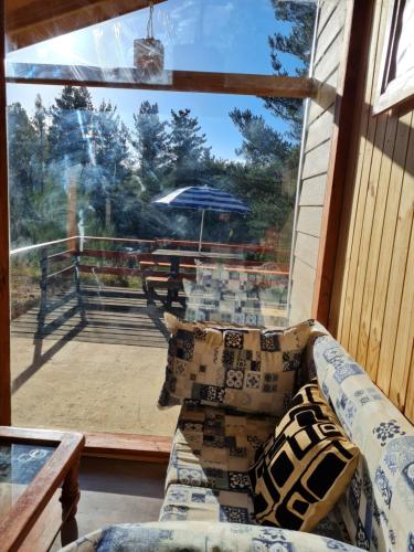 a couch on a porch with a view of a patio at Cabaña Refugio Sauna Spa El Arrayan Casablanca Valdivia in Valdivia