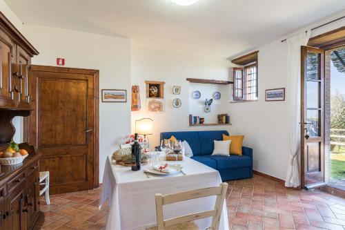 a living room with a table and a blue couch at Il Poderino in Monteriggioni