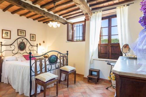 a bedroom with a bed and chairs in a room at Il Poderino in Monteriggioni
