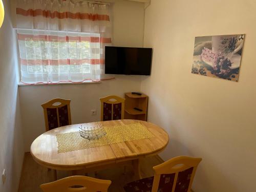 a dining room with a wooden table and a television at Martinov dom in Kranjska Gora