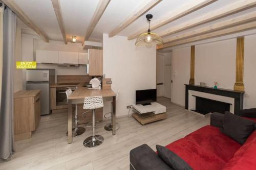 ein Wohnzimmer mit einem roten Sofa und einer Küche in der Unterkunft La Tournette - Apartment for 2-4 people in the heart of the old town in Annecy