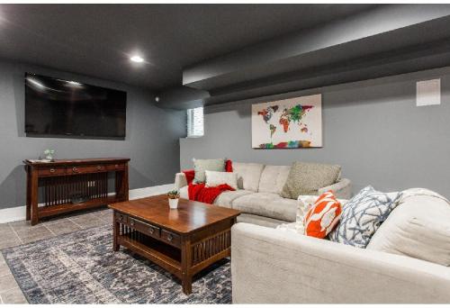 a living room with a couch and a tv at Forrestville Ave Large Suite in Chicago