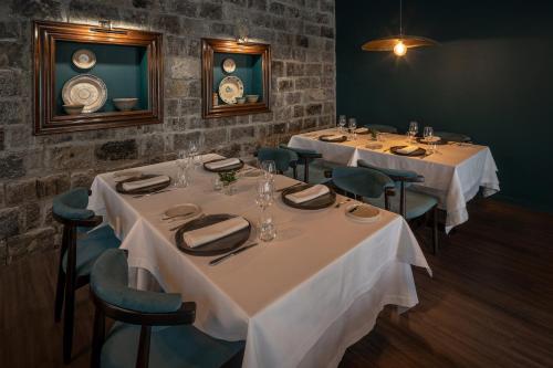 a dining room with two tables with white tablecloths at Senhora da Rosa, Tradition & Nature Hotel in Ponta Delgada
