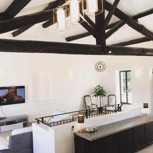 a living room with white walls and a ceiling with beams at Villa Napoléon Piscine&Jacuzzi in Le Somail