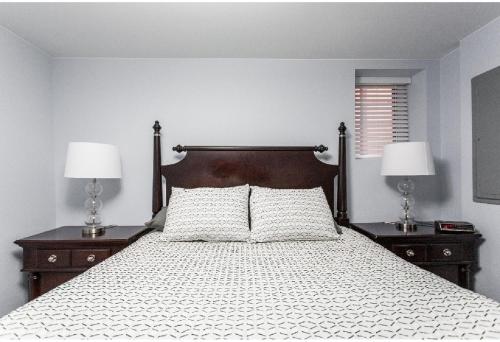 a bedroom with a bed with two nightstands and two lamps at Forrestville Ave Large Suite in Chicago