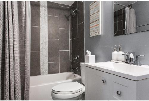 W łazience znajduje się toaleta, umywalka i wanna. w obiekcie Forrestville Ave Large Suite w Chicago