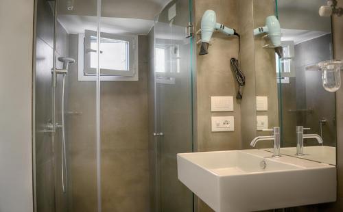a bathroom with a sink and a shower at Sunshine Luxury Rooms in Ostuni