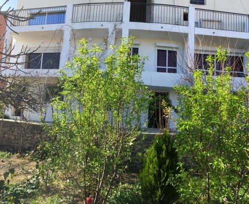 a white building with trees in front of it at Taza Organic Garden with view park and restaurant in Taza