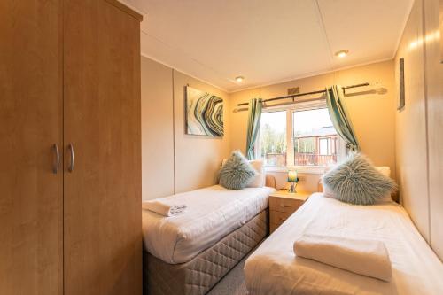 Woodland Lodge With Hot Tub tesisinde bir odada yatak veya yataklar