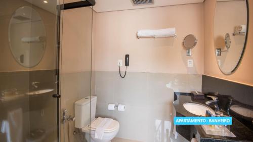 a bathroom with a shower and a toilet and a sink at Vila Galé Rio de Janeiro in Rio de Janeiro