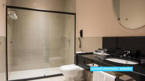 a bathroom with a shower and a toilet and a sink at Vila Galé Rio de Janeiro in Rio de Janeiro