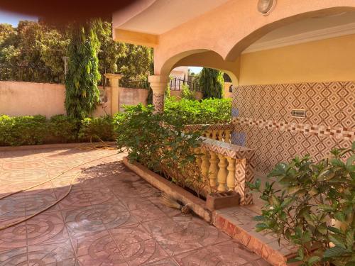 a house with a stone fence and a courtyard at Villa Chambre C climatisée douche Cuisine salon in Bamako