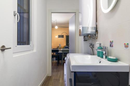 a white bathroom with a sink and a mirror at SPAZIO M&M CELLINI 3 in Milan