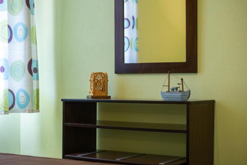 a shelf with a mirror and a toy boat on it at Niriides in Porto Koufo