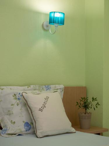 a pillow sitting on a bed with a blue lamp at Niriides in Porto Koufo