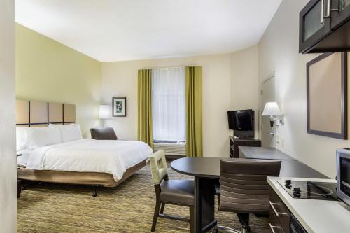 a hotel room with a bed and a table at Candlewood Suites Virginia Beach Town Center by IHG in Virginia Beach