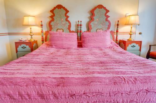 a pink bed with two pink pillows on it at Hofsas House Hotel in Carmel