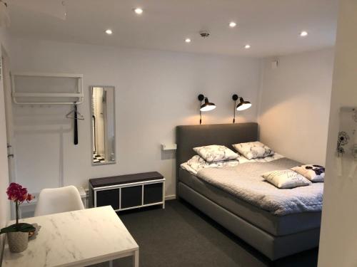 a bedroom with a bed with two lamps on it at Smultronstallet Gårdshotell in Valleberga
