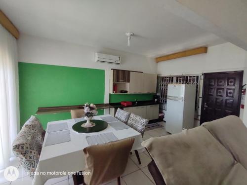 eine Küche mit einem Tisch und einer grünen Wand in der Unterkunft Casa para hospedagem temporário in Joinville