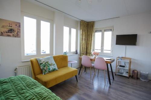 a bedroom with a bed and a table and chairs at El Puerto Bed and Breakfast in Hoorn