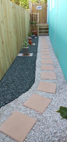 a backyard walkway with rocks and a fence at Mar Bonita Beach Appartment II in Isabela