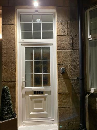a white door on the side of a brick building at HLA Holytown in Mossend