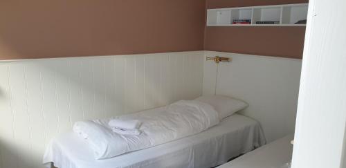 um quarto com uma cama branca com uma cruz em bb kanstrup em Frederikshavn