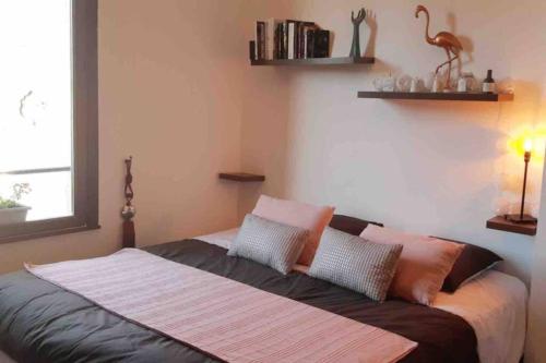 a bedroom with a bed with pillows and a bird on the wall at Le XV in Nancy
