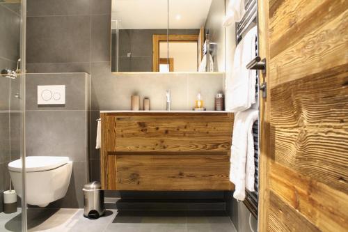 High-End & Central for up to 6 guests, Ambassadeurs في كرانس مونتانا: حمام مع حوض خشبي ومرحاض