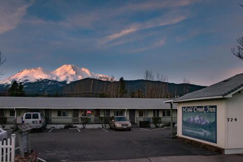 a hotel parking lot with a mountain in the background at Cold Creek Inn in Mount Shasta