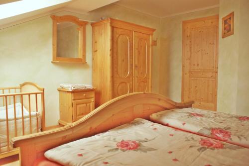 a bedroom with a bed and a crib in a room at Sunnhof in Oberhofen am Irrsee