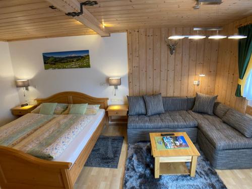 ein Schlafzimmer mit einem Bett und einem Sofa in der Unterkunft Gästehaus Amort in Ramsau bei Berchtesgaden