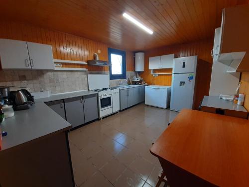 a large kitchen with white appliances and a wooden ceiling at Pensiunea Valurile Dunarii in Sfântu Gheorghe