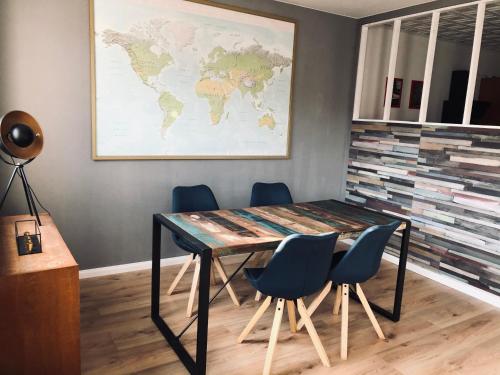 una mesa con sillas y un mapa mundial en la pared en Schwarzburg Appartments, en Sondershausen