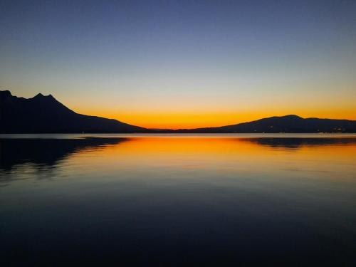 a sunset over a lake with mountains in the background at Ferienwohnung Lindpointner in Innerschwand am Mondsee