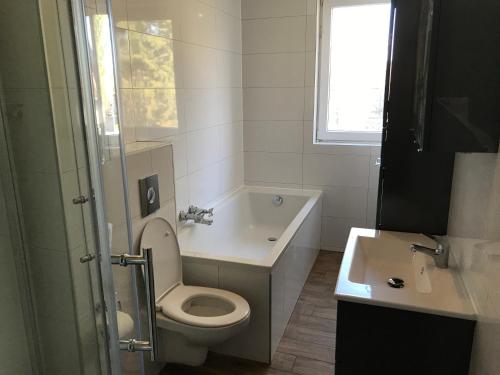 a white bathroom with a toilet and a sink at Biker's Base Baddeckenstedt in Baddeckenstedt