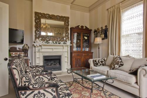 a living room with a couch and a fireplace at Lilac Rose Boutique Bed and Breakfast in Christchurch