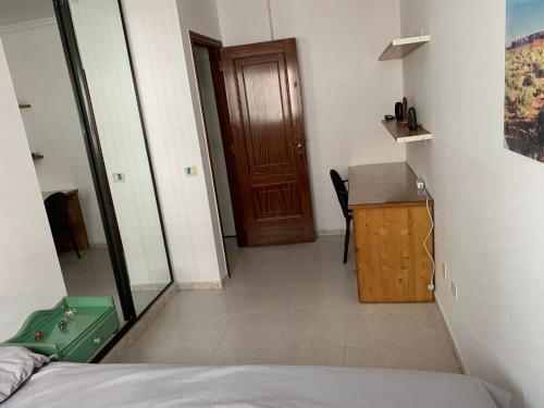 sypialnia z łóżkiem, biurkiem i drzwiami w obiekcie guajara-loft w mieście La Laguna