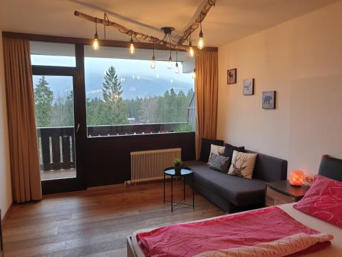 ein Wohnzimmer mit einem Sofa und einem großen Fenster in der Unterkunft Apartment Noemi in Bad Goisern