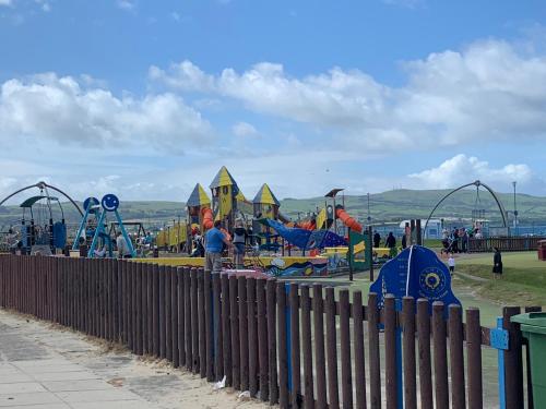 a park with a playground with slides and rides at Ayr Loft Apartment with Fabulous Views in Ayr