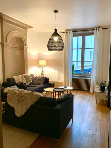 a living room with a couch and a table at Le Breuil - Spacieux, Chaleureux, Emplacement Idéal in Vesoul