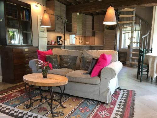 a living room with a couch and a table at Charmante Maison entre les Pommiers in Fresne-le-Plan