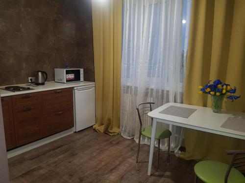 una pequeña cocina con mesa y mesa con sillas en Apartment Sports Palace Просторная квартира рядом Дворец Спорта, en Járkov