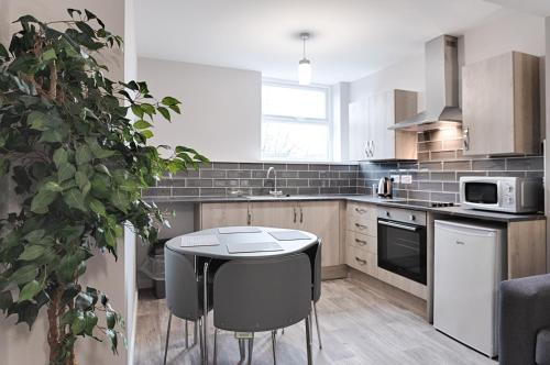 a kitchen with a small table and a microwave at Copper House- Smart Stay near Stadium & City in Swansea