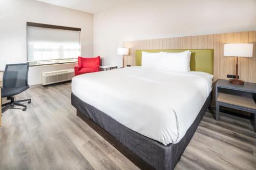 a hotel room with a large bed and a desk at Country Inn & Suites by Radisson, Stone Mountain, GA in Stone Mountain