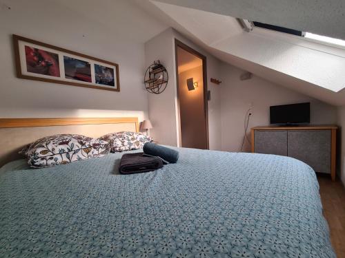 een slaapkamer met een bed met een tas erop bij Corniche de la Plage classé 3 étoiles in Bénodet