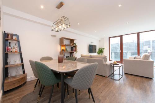 a dining room and living room with a table and chairs at City Living apartments in London