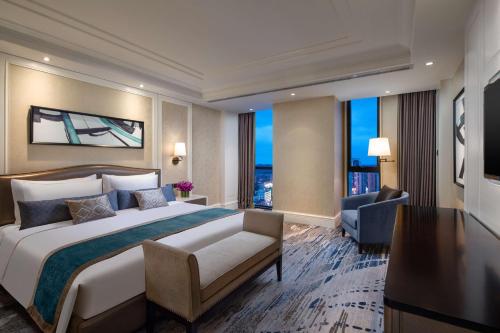 Pokój hotelowy z łóżkiem i biurkiem w obiekcie Ramada Plaza by Wyndham Wuhan Huangpi w mieście Wuhan