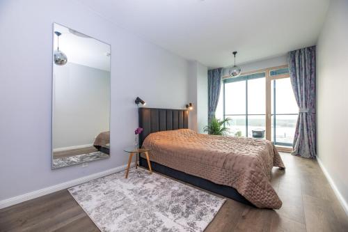 a bedroom with a bed and a large window at Charming Apt with Spectacular Baltic Sea Views in Klaipėda